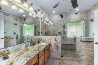 bathroom with vanity, an enclosed shower, and ceiling fan