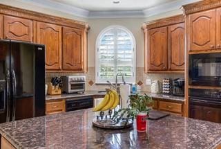 kitchen featuring crown molding, decorative backsplash, and black appliances