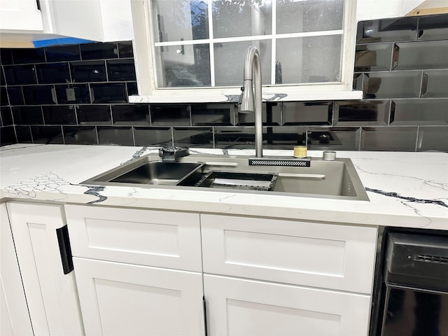 kitchen with sink, white cabinetry, light stone counters, dishwashing machine, and backsplash