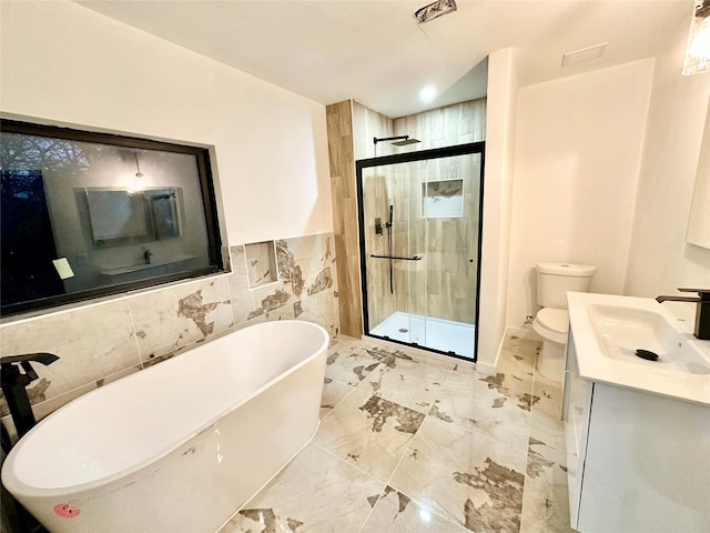 full bathroom featuring toilet, vanity, shower with separate bathtub, and tile walls