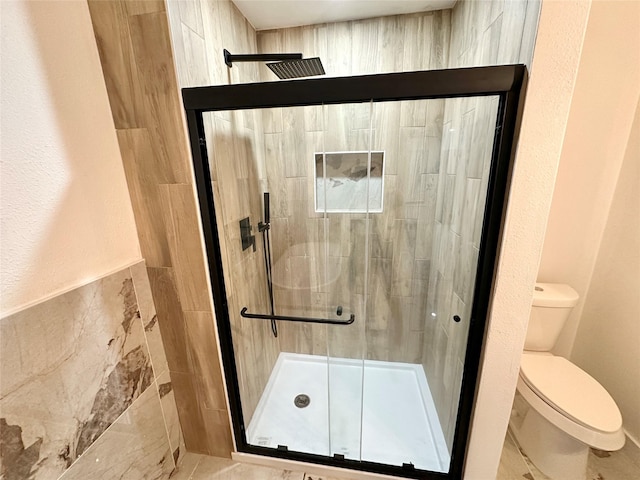 bathroom featuring an enclosed shower, tile walls, and toilet