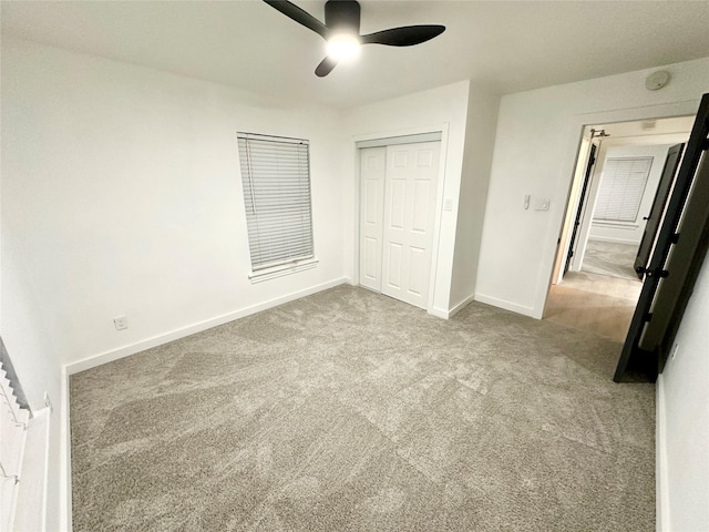 unfurnished bedroom with ceiling fan, carpet flooring, and a closet