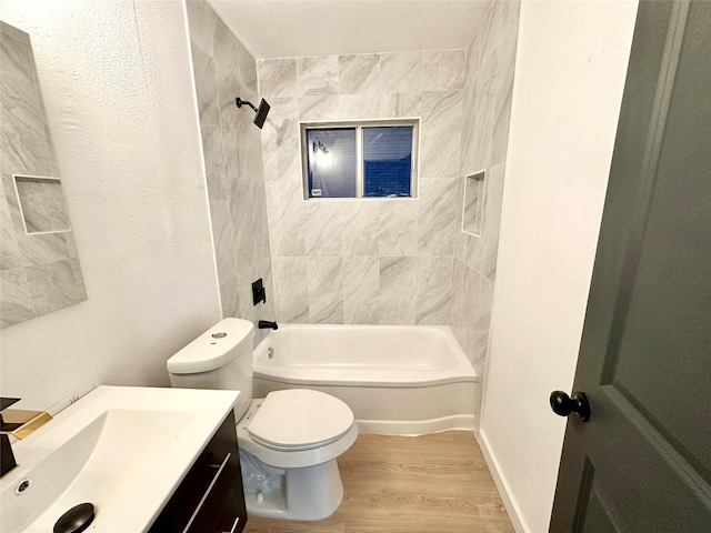 full bathroom with hardwood / wood-style flooring, tiled shower / bath, vanity, and toilet