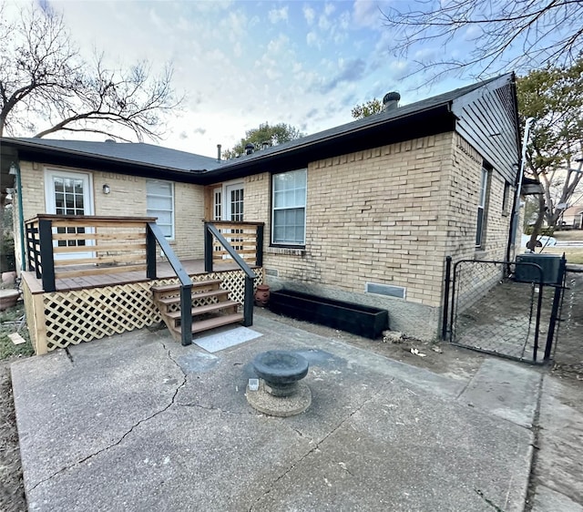 rear view of property with a deck and a patio area