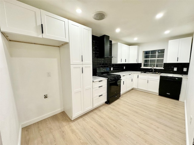 kitchen featuring sink, light hardwood / wood-style flooring, black appliances, white cabinets, and wall chimney exhaust hood