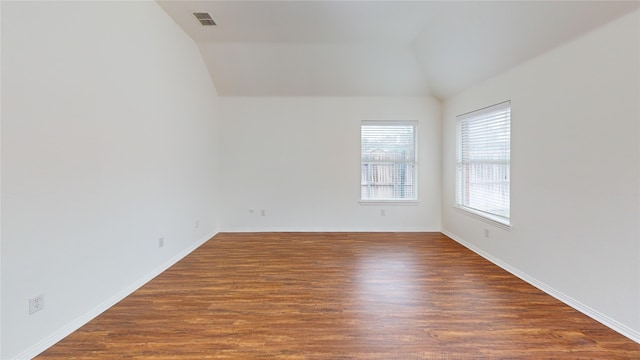 unfurnished room featuring vaulted ceiling and dark hardwood / wood-style floors