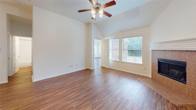 unfurnished living room featuring a tiled fireplace, ceiling fan, vaulted ceiling, and dark hardwood / wood-style flooring