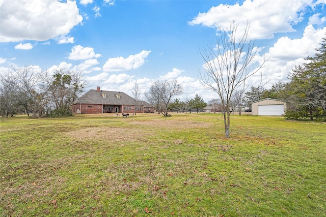 view of yard featuring a garage and an outdoor structure