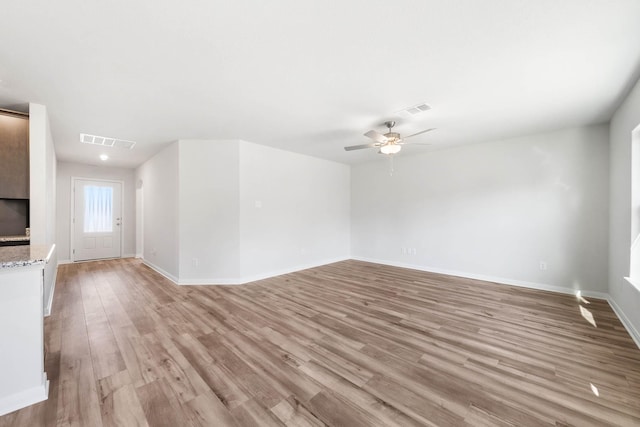 unfurnished living room featuring ceiling fan and light wood-type flooring