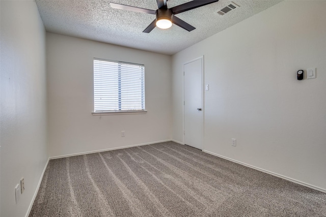 carpeted empty room featuring ceiling fan and a textured ceiling