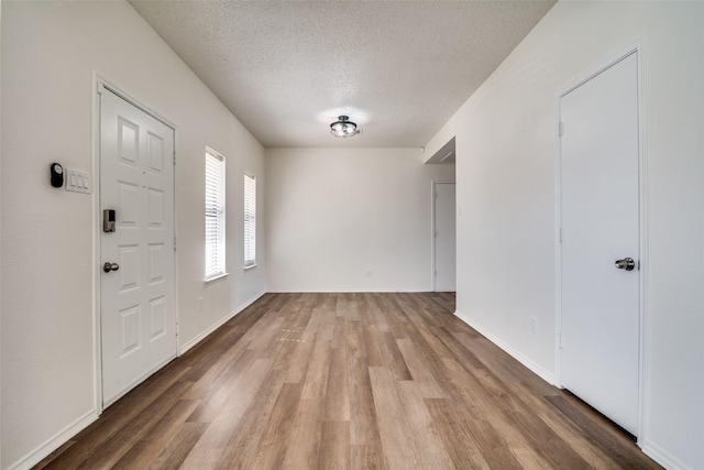 entryway featuring a textured ceiling and light hardwood / wood-style flooring