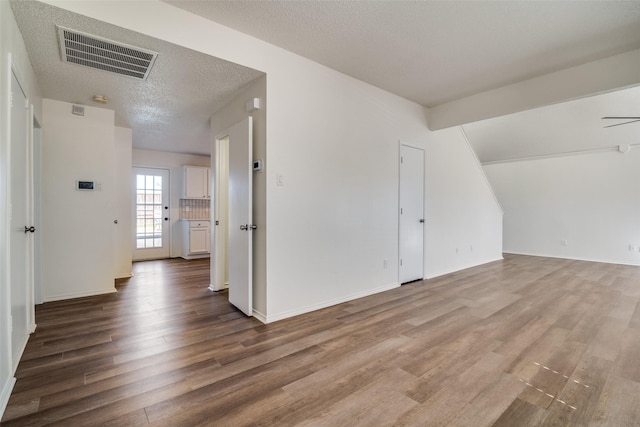 additional living space with hardwood / wood-style flooring and a textured ceiling