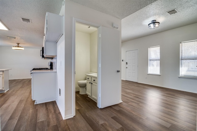 kitchen featuring white cabinetry, dark hardwood / wood-style floors, and a textured ceiling