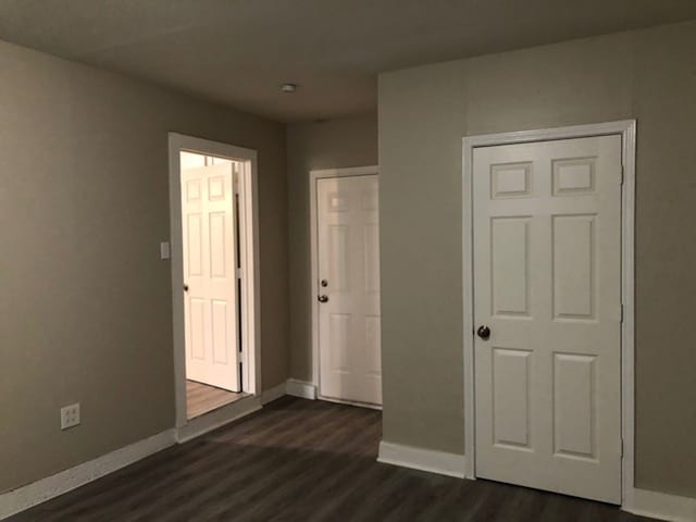 unfurnished bedroom with dark hardwood / wood-style flooring