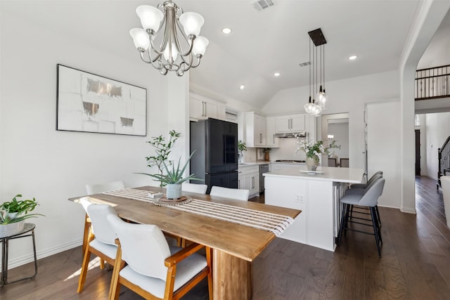 dining space with a notable chandelier, dark wood-type flooring, and vaulted ceiling