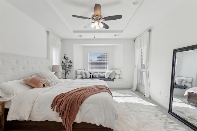 bedroom featuring access to outside, light colored carpet, a raised ceiling, and ceiling fan