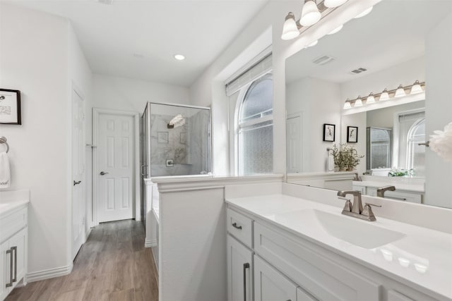 bathroom featuring hardwood / wood-style flooring, vanity, and a shower with shower door