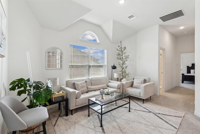 carpeted living room with high vaulted ceiling