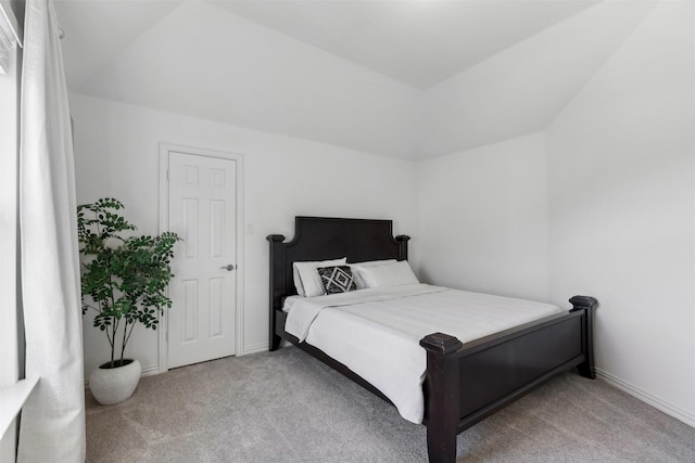 bedroom with lofted ceiling and light carpet