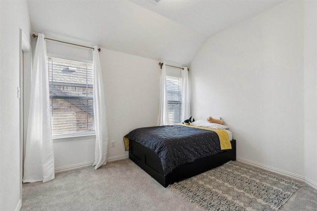 bedroom with vaulted ceiling and light colored carpet