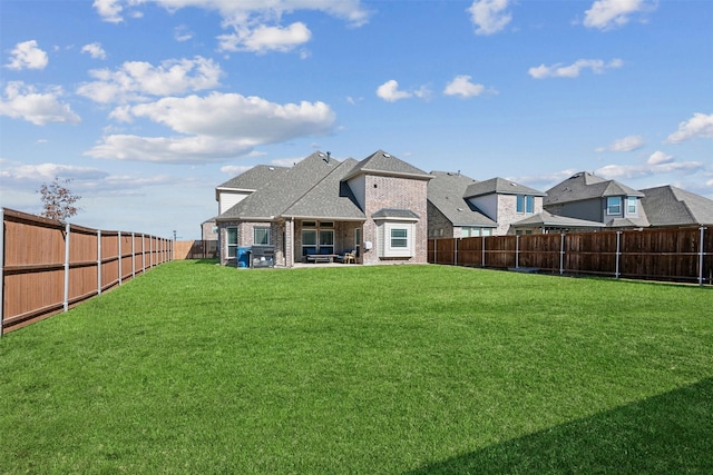 rear view of house featuring a yard and a patio