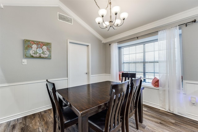 dining room featuring crown molding, dark wood-type flooring, a chandelier, and vaulted ceiling