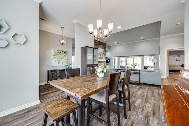 dining space featuring dark hardwood / wood-style flooring, crown molding, and an inviting chandelier