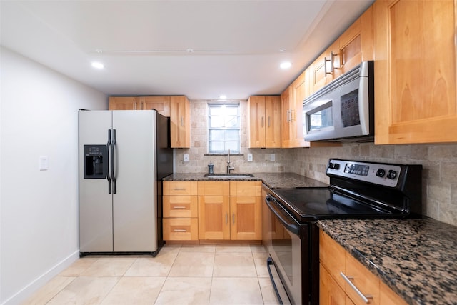 kitchen featuring sink, light tile patterned floors, dark stone countertops, backsplash, and stainless steel appliances