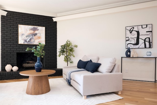 living room featuring a brick fireplace, crown molding, and light hardwood / wood-style floors