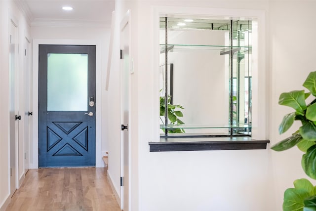 entryway featuring ornamental molding and light hardwood / wood-style flooring