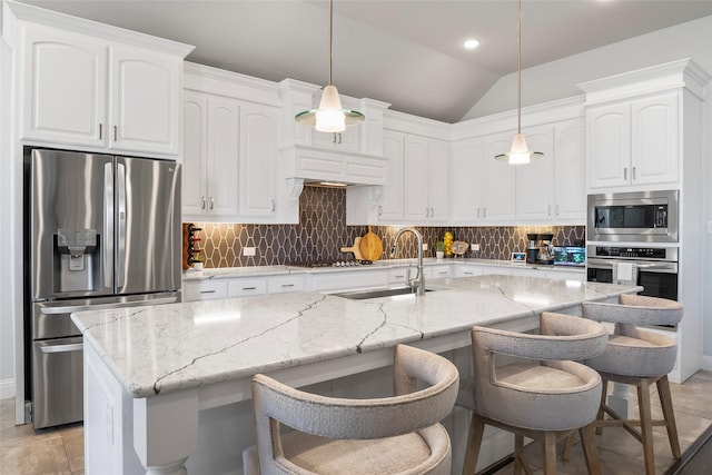 kitchen featuring hanging light fixtures, appliances with stainless steel finishes, sink, and white cabinets