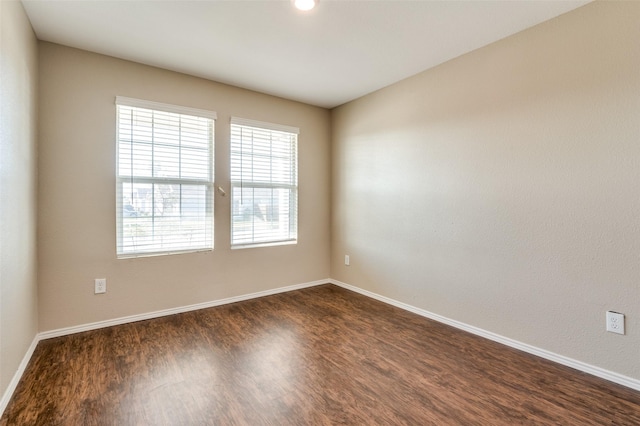 empty room with dark hardwood / wood-style flooring