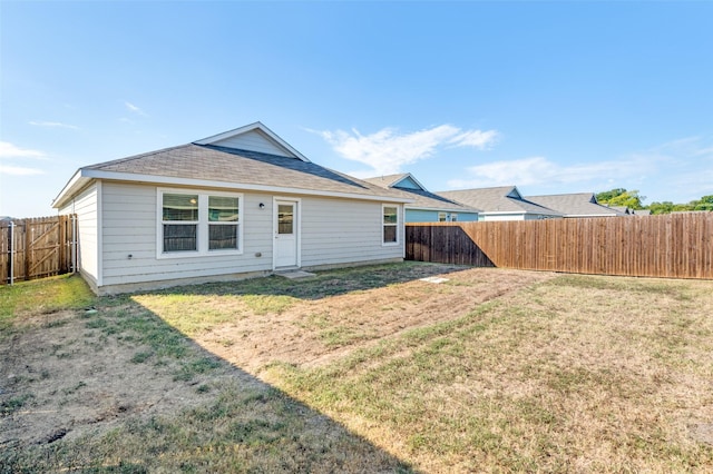 rear view of property featuring a lawn