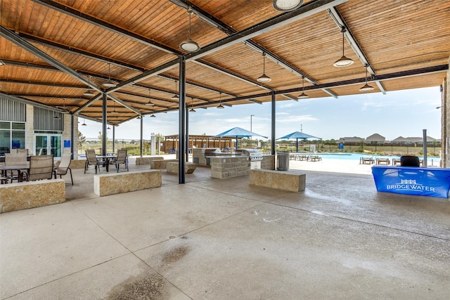 view of patio featuring a pool, an outdoor kitchen, a grill, and a water view