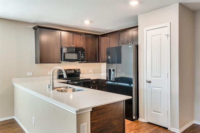 kitchen featuring sink, dark brown cabinetry, black appliances, kitchen peninsula, and light wood-type flooring