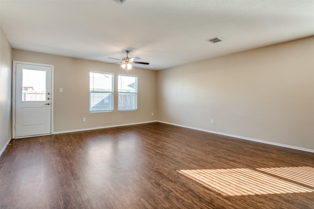 empty room featuring dark wood-type flooring and ceiling fan