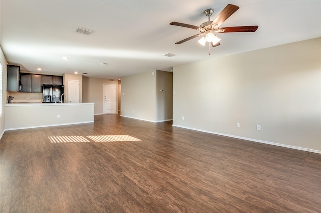 unfurnished living room featuring ceiling fan, dark hardwood / wood-style floors, and sink