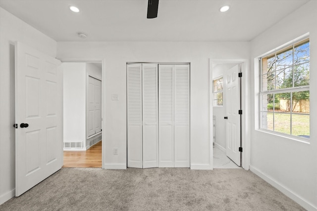 unfurnished bedroom with light carpet and ceiling fan