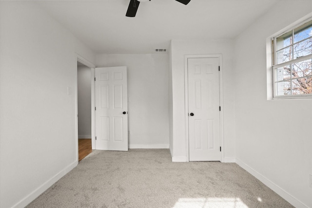 unfurnished bedroom with light carpet and ceiling fan