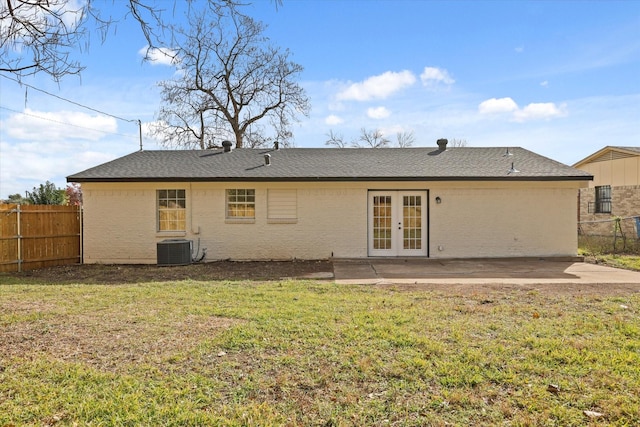 rear view of property with french doors, a yard, central AC, and a patio area