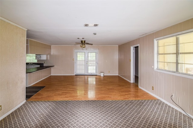 unfurnished living room featuring hardwood / wood-style floors, ornamental molding, and ceiling fan