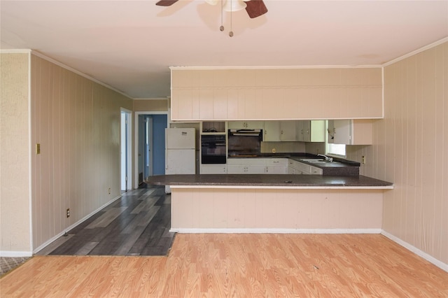 kitchen featuring crown molding, white refrigerator, white cabinets, kitchen peninsula, and light wood-type flooring