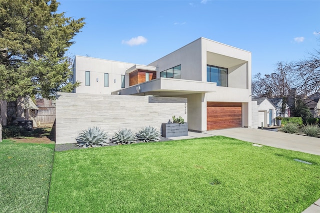 contemporary home featuring a garage and a front lawn