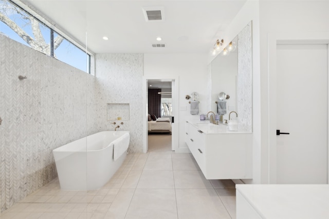 bathroom with vanity, a washtub, and tile patterned floors