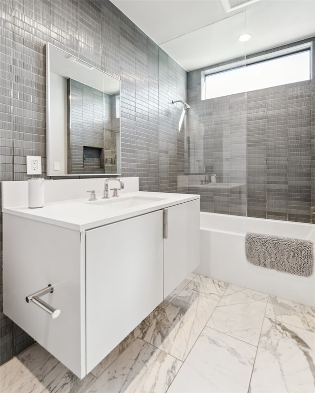 bathroom with tiled shower / bath, tile walls, and vanity