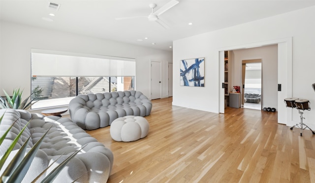 living room with ceiling fan and light hardwood / wood-style floors