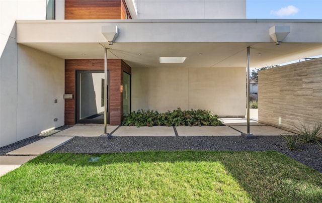 property entrance featuring ceiling fan and a lawn