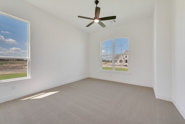 carpeted spare room featuring ceiling fan