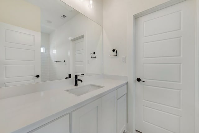 bathroom featuring vanity and tiled shower