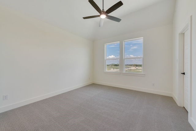 empty room featuring ceiling fan, light colored carpet, and vaulted ceiling